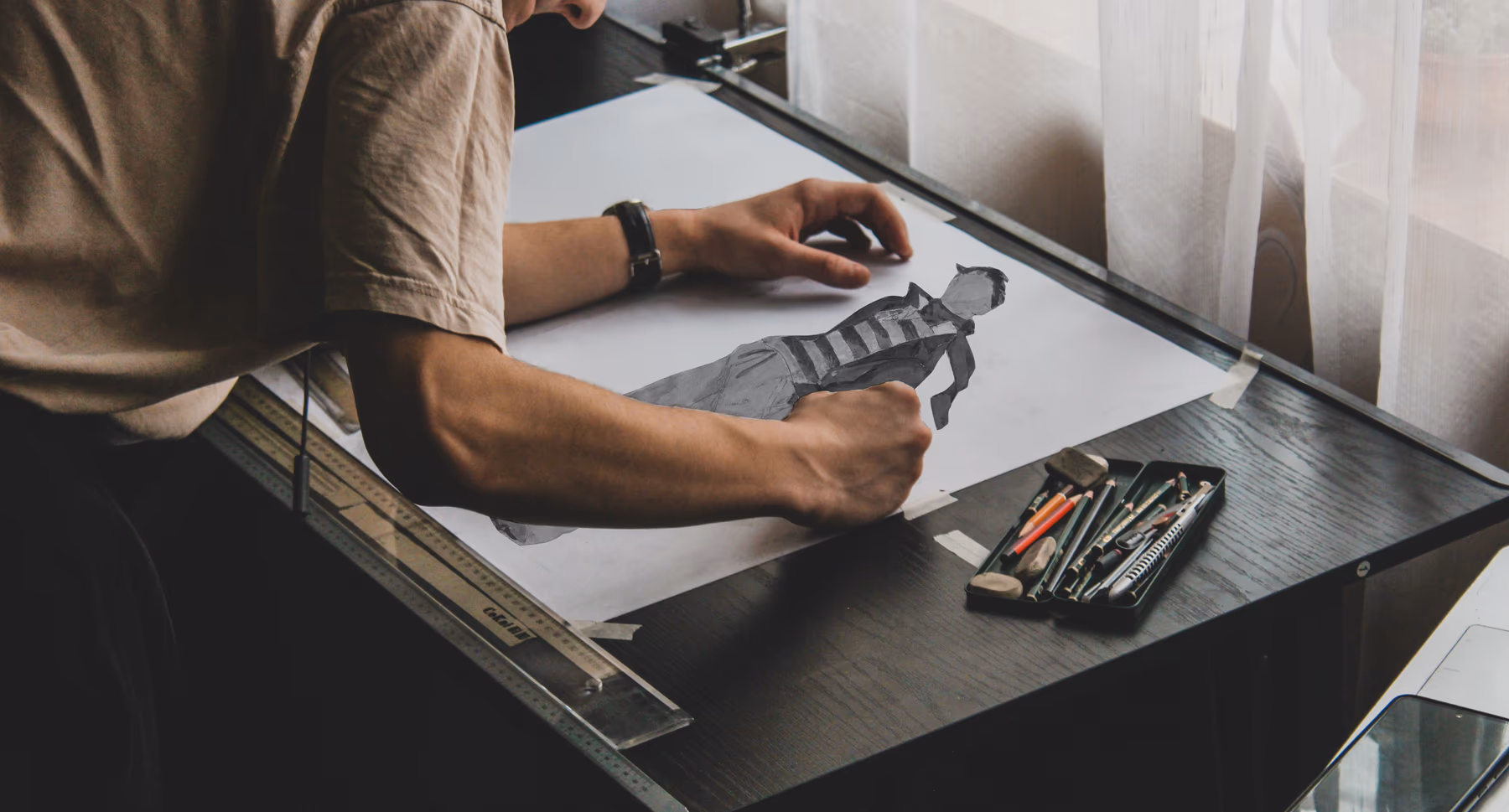 Sketching a fashion croquis at the drafting table
